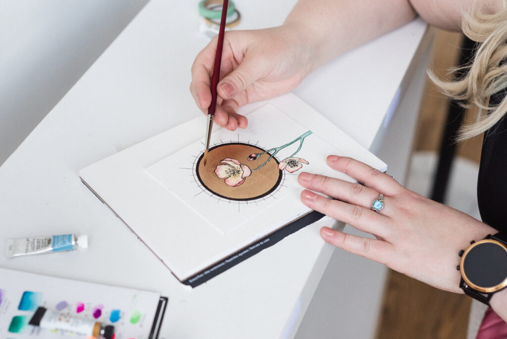 Graphic designer Mahala Bloom illustrates a flower with ink and watercolor on watercolor paper.